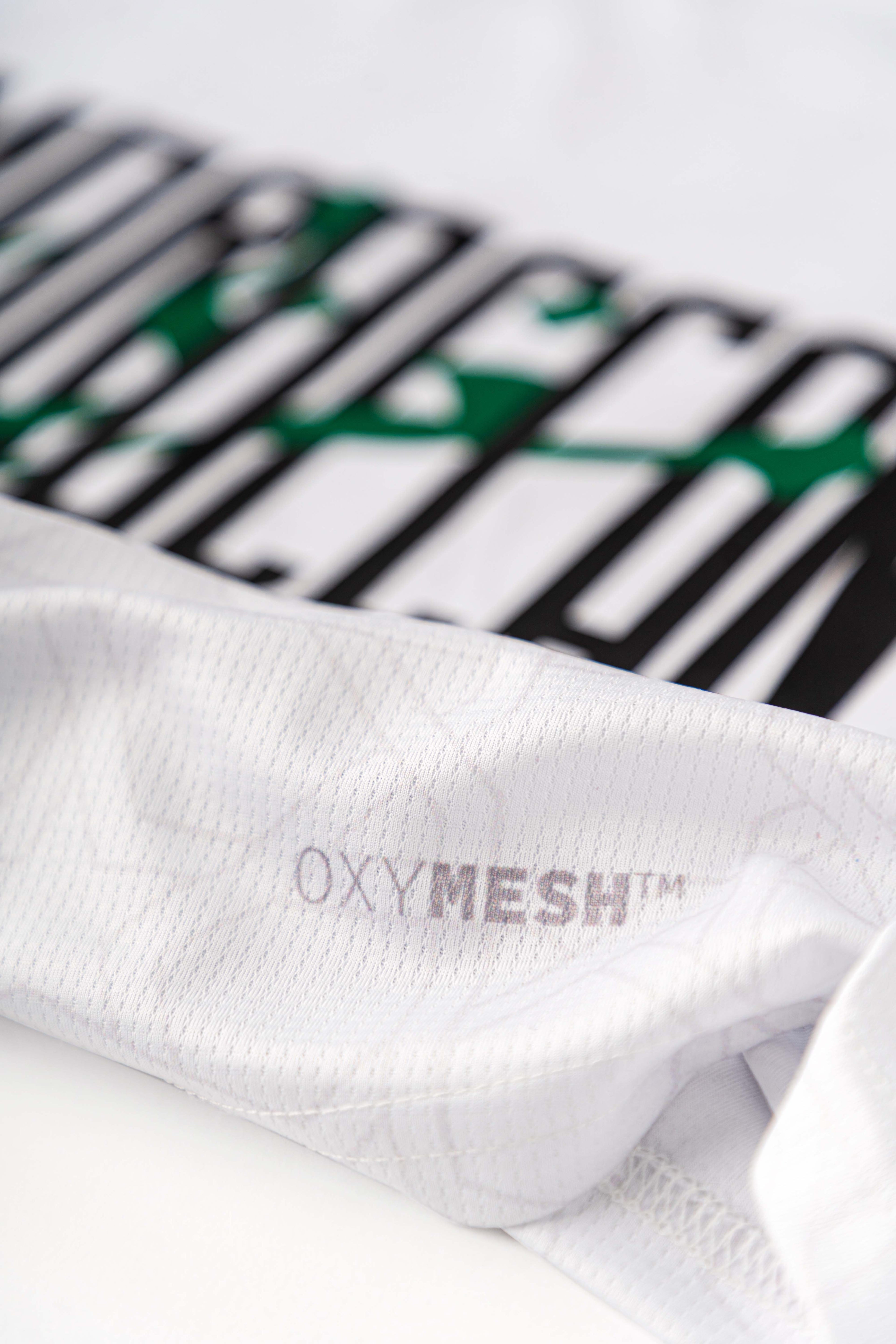 Close-up of the Lions Wear Moroccan AURA jersey showing OXYMESH™ breathable fabric and a partial view of the front print design.